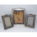 Three silver photo frames. One pair of silver repousse design photo frames with urn and floral