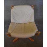 A laminated beech framed easy chair with a leather drop in seat on canvas frame. H.83 x 73cm