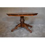 A burr walnut shaped top coffee table on quadruped carved supports. H.95cm x 60cm.