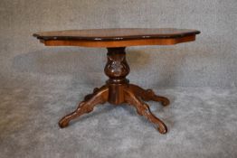 A burr walnut shaped top coffee table on quadruped carved supports. H.95cm x 60cm.