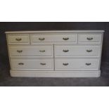 A cream lacquered Victorian style bank of seven drawers. H.70 x 140cm