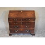 A Georgian mahogany bureau with fall front revealing fitted interior above four long drawers on