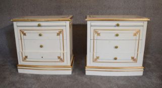 A pair of cream and gilt bedside cabinets fitted two drawers and slide each with plate glass top.
