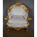 A large gilt framed armchair in the Baroque style with cream fabric upholstery. H.110 x 85 x 50cm