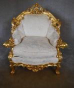 A large gilt framed armchair in the Baroque style with cream fabric upholstery. H.110 x 85 x 50cm