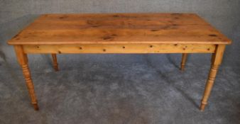 A large pine kitchen dining table on turned tapering supports. L.183 x H.75cm