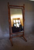 A large Regency mahogany framed cheval mirror with adjustable original plate on swept supports
