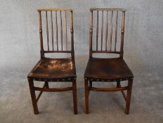A pair of oak spindle back dining chairs in leather upholstery. H.97 x 46cm