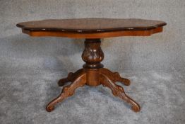A burr walnut shaped top coffee table on quadruped carved supports. 95cm x 60cm.
