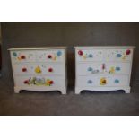 A pair of white painted pine chest of drawers with two short over two long drawers. Decorated with
