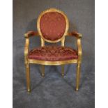 A Louis XVI style gold framed open armchair in rouge damask upholstery. H.104 x 62cm