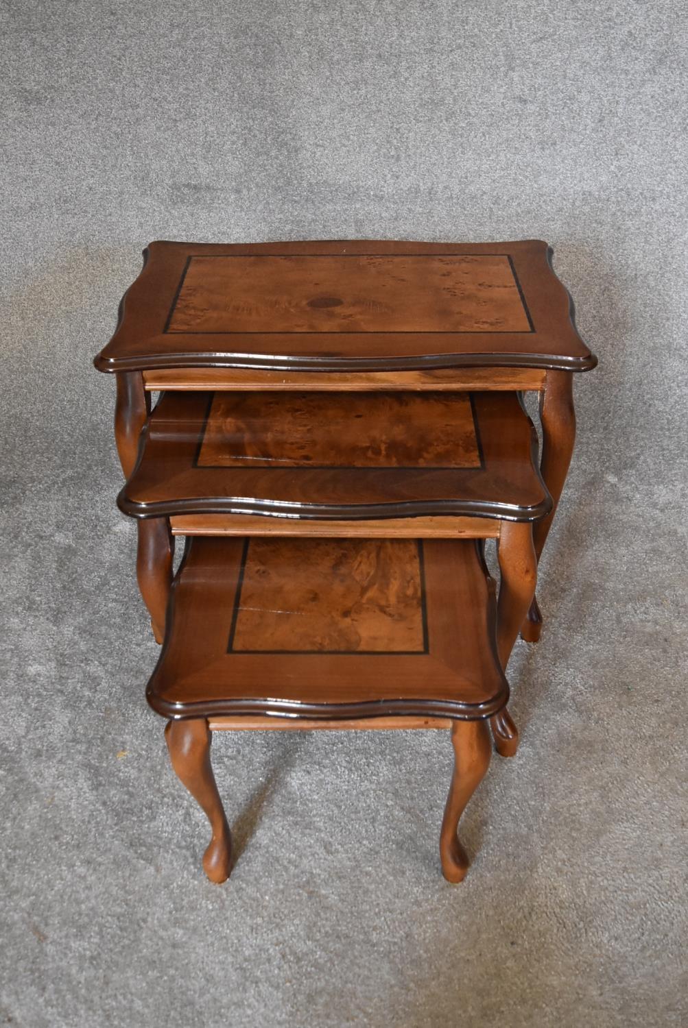 A nest of three graduating burr walnut occasional tables on cabriole supports. Largest - H.47 x 60cm