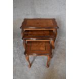 A nest of three graduating burr walnut occasional tables on cabriole supports. Largest - H.47 x 60cm