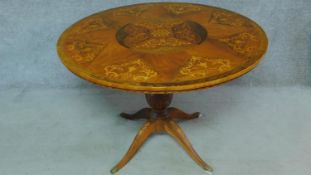 A 19th century Continental walnut and satinwood inlaid circular table raised on fluted quadruped