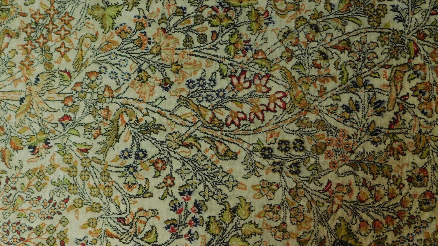 A Persian rug depicting a tree with repeating spandrels and petal motifs surrounded by geometric - Image 2 of 4