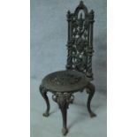 A 19th century cast iron Coalbrookdale style high back chair with cast floral design raised on