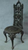 A 19th century cast iron Coalbrookdale style high back chair with cast floral design raised on