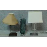 A trio of three contemporary lights one with a blown glass blue grey tree trunk form base, one