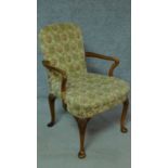 An early Georgian style walnut armchair with floral upholstery and raised on shell motif carved