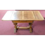 A mid 20th century oak draw leaf dining table with carved baluster supports in the Jacobean style.