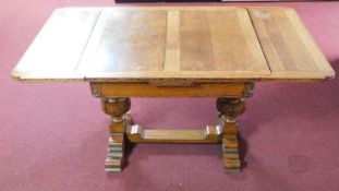 A mid 20th century oak draw leaf dining table with carved baluster supports in the Jacobean style.