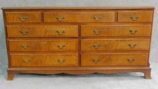 A Georgian style mahogany and crossbanded chest with an arrangement of nine drawers on bracket feet.
