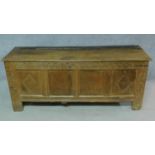 An antique oak coffer fitted with fabric on the inside and carved with floral and diamond motifs