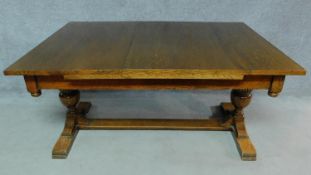 A Jacobean style oak dining table with leaves, raised on reeded stretchered turned supports. H.76