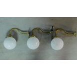 A set of three brass wall lamps with opaque glass spherical shades. H.26 D.29cm