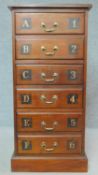 A tall mahogany filing chest with inset tooled leather top and lettered and numbered drawers on