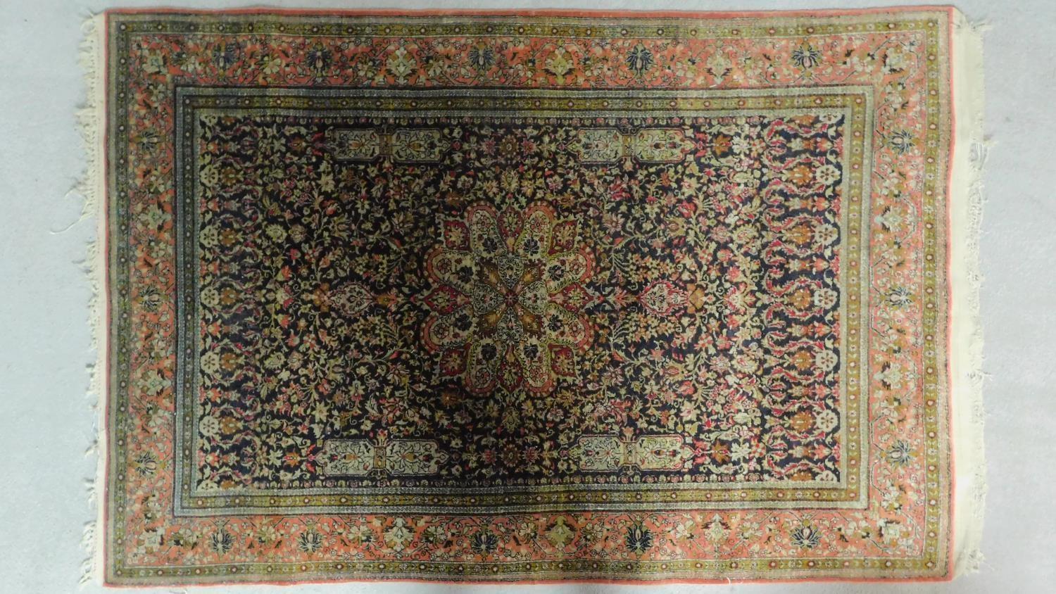 A Persian style rug with central medallion surrounded by floral motifs and a floral and geometric