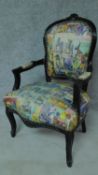 A French style ebonised armchair with comic strip upholstery. H.93cm