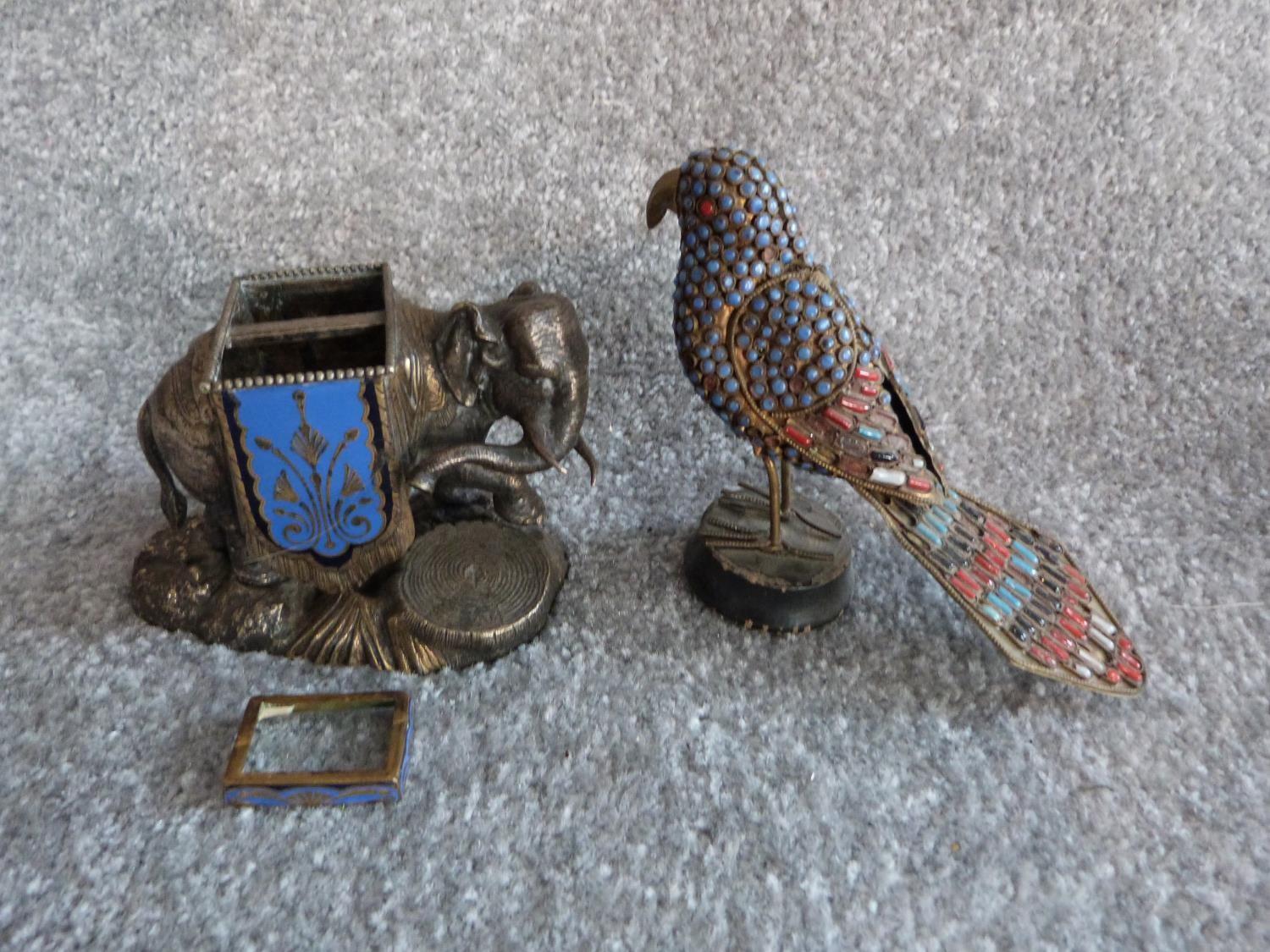 An antique silver plate and blue enamel elephant match holder with gilded details and an Indian