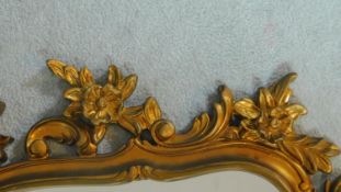 A arched gilt framed overmantel mirror with floral cresting. 116x122cm