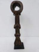 A wooden African tribal tool on metal display stand. H 25cm.