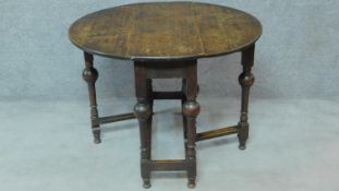 A Jacobean style oak drop flap dining table on turned stretchered supports. H.73 W.98 D.92cm