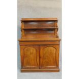 A Regency mahogany two door chiffonier with graduated open shelves to the superstructure above