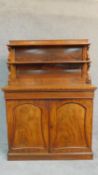 A Regency mahogany two door chiffonier with graduated open shelves to the superstructure above