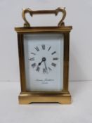 A 20th century brass carriage clock by Charles Frodsham, London, with bevelled glass sides and white