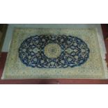 A Persian Kashan style rug, central floral medallion on a dark blue ground, within stylised floral