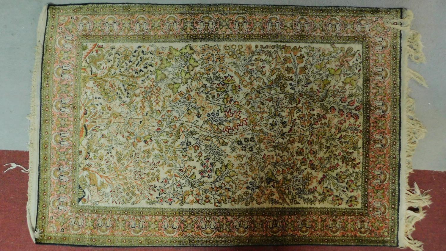 A Persian rug depicting a tree with repeating spandrels and petal motifs surrounded by geometric