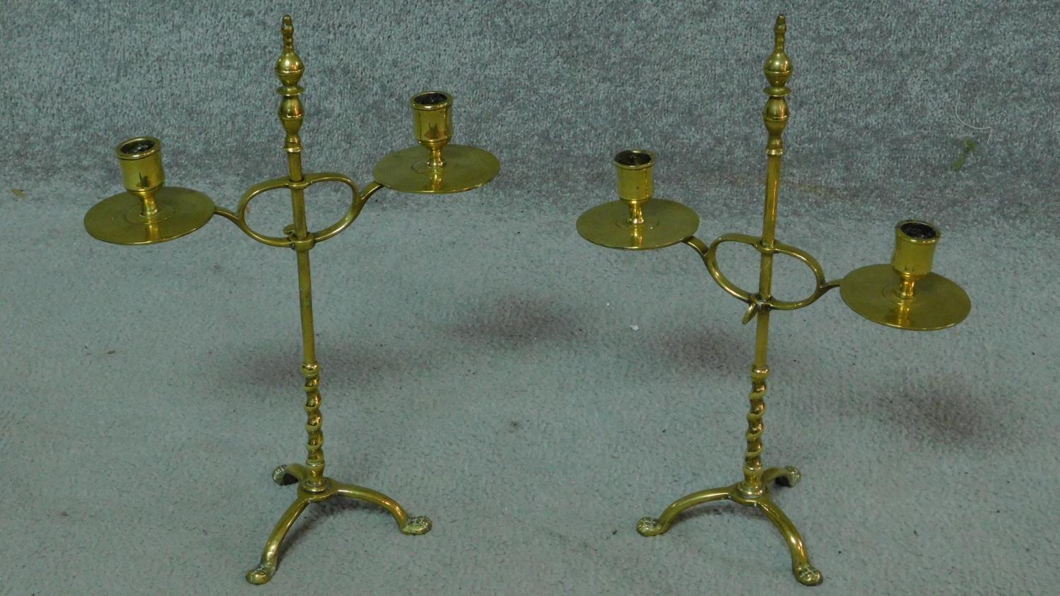 A pair of 19th century brass adjustable candelabras with twisted stem and standing on three lion paw