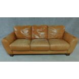 A pale tan leather three seater sofa on block feet. H.80 W.208 D.88cm
