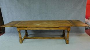 A Victorian oak refectory table in the antique style with draw leaves on turned stretchered base.