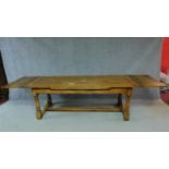 A Victorian oak refectory table in the antique style with draw leaves on turned stretchered base.