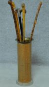 Six wooden canes, one with metal handle in a brass umbrella stand. H.90 (tallest cane)