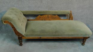 A Victorian beech framed chaise longue decorated with floral carvings and raised on turned supports.