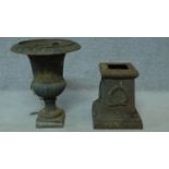 A cast iron urn and base with wreath motif and stylised geometric border. H.62cm
