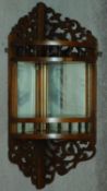 A 19th century walnut mirrored back open corner cabinet with pierced fretwork. H.64cm