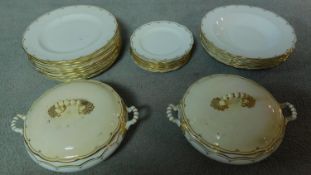 An antique gilded and cream porcelain part dinner set by Maple and Co of London.